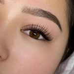 Close-up view of classic lash extensions applied to an eye, showing a soft natural matte black lash finish