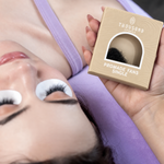 Lash artist applying extensions beside a Thousandlashes Pro-Made Fans box