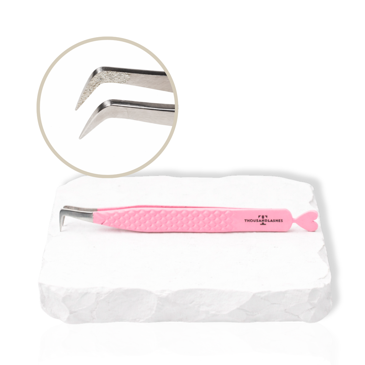 Pink Thousandlashes angled lash tweezer with close-up view of the tip on a white stone surface.