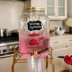 Pink and fruit-infused drink dispenser prepared for event guests.