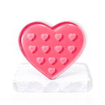 Pink heart-shaped lash glue holder palette with multiple heart-shaped wells on a white display base for eyelash extension artists
