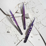 Purple eyelash extension tweezers displayed on a marble surface, showing different tweezer tips and designs for precision lash application.