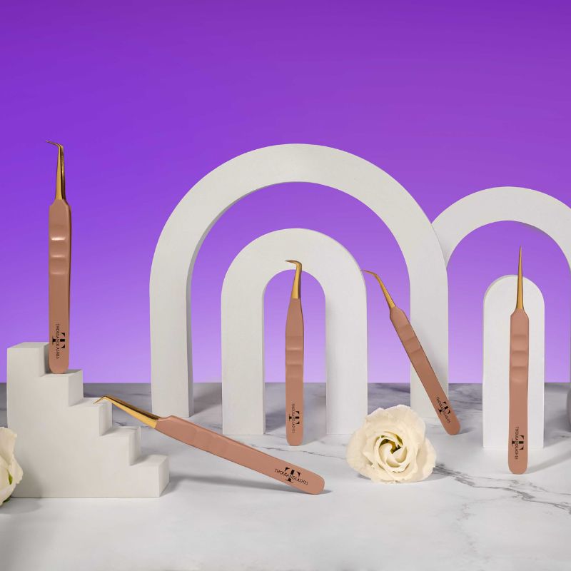 Thousand Lashes rose gold lash tweezers displayed on white arches with a purple background for professional eyelash extension tools.