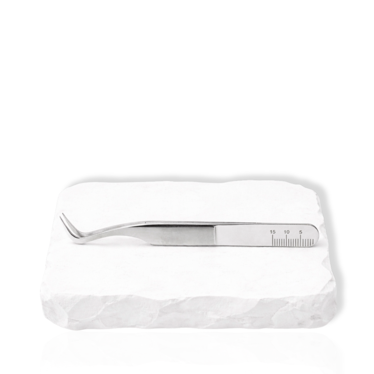 Thousandlashes M Narrow silver lash tweezer shown from the reverse side on a white stone surface.