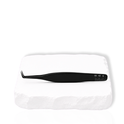 Thousandlashes Noir Collection 90-degree tweezer on a white stone surface.