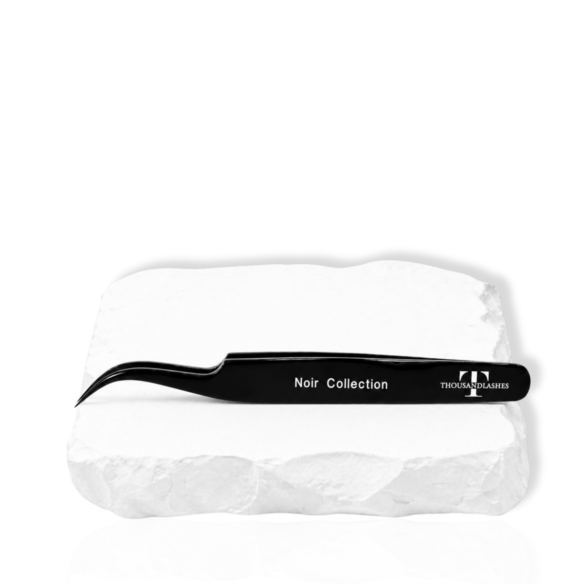 Thousandlashes Noir Collection precision curved tweezer on a white stone surface.