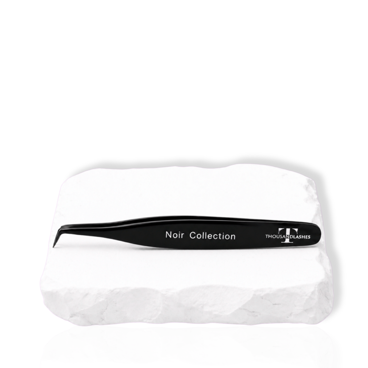 Thousandlashes Noir Collection tweezer on a white stone surface.