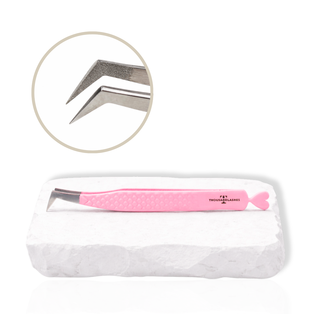 Pink Thousandlashes angled lash tweezer with close-up view of the tip on a white stone surface.