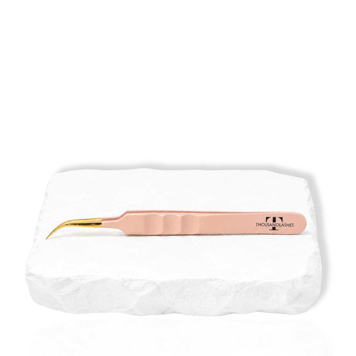 Thousandlashes nude curved lash tweezer on a white stone surface.