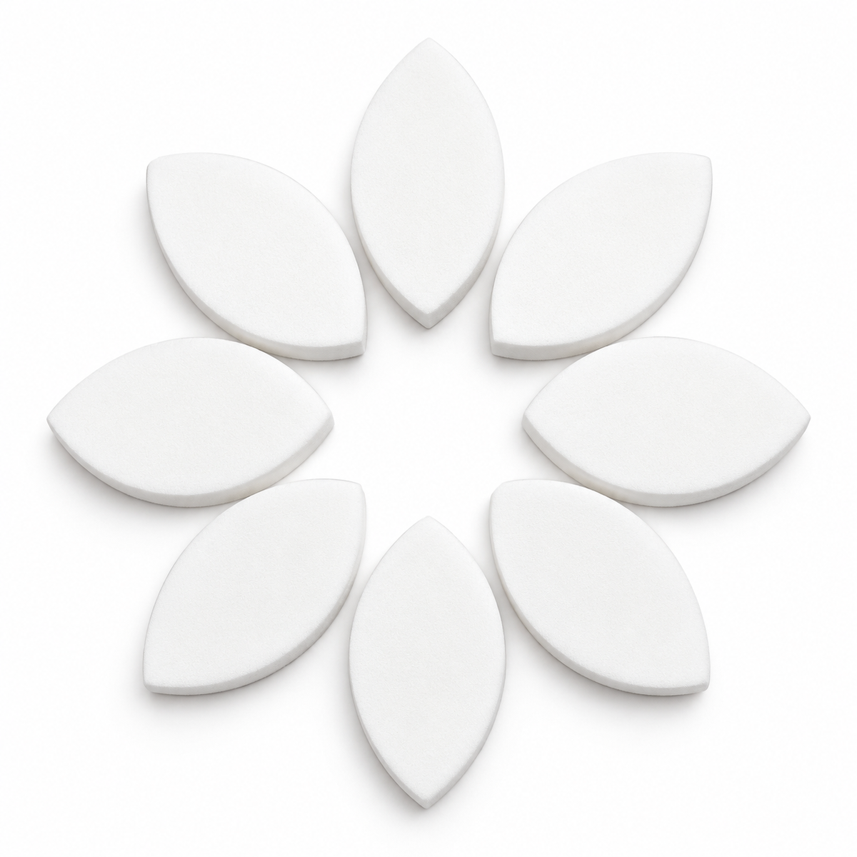 White eyelid shaped practice sponges arranged in a circular pattern for eyelash extension training and lash mapping practice.