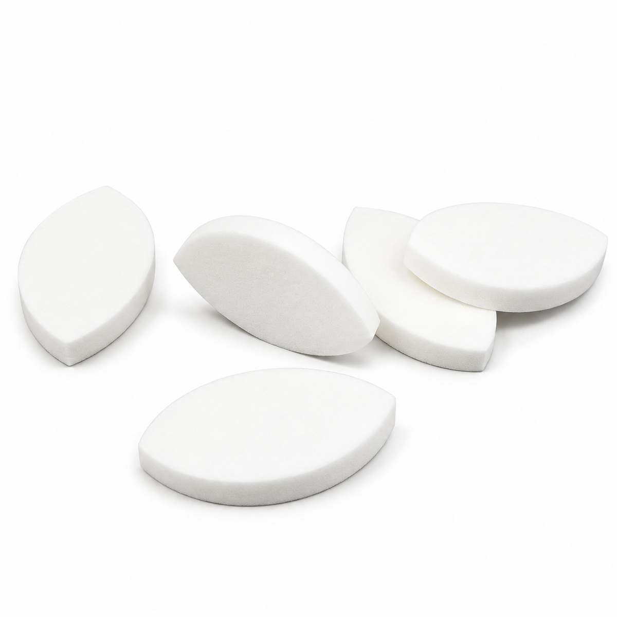 White eyelid shaped practice sponges arranged on a white background for eyelash extension training and lash mapping practice.