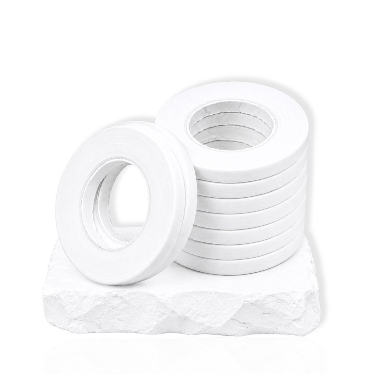 White narrow lash tape rolls stacked on a white stone surface for eyelash extension application