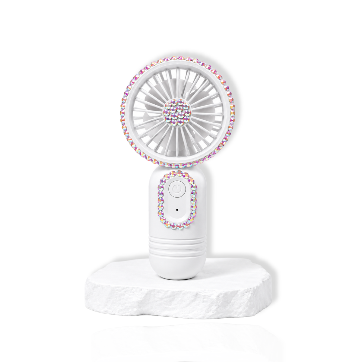 White portable lash fan with rhinestone detailing displayed on a white stone surface.